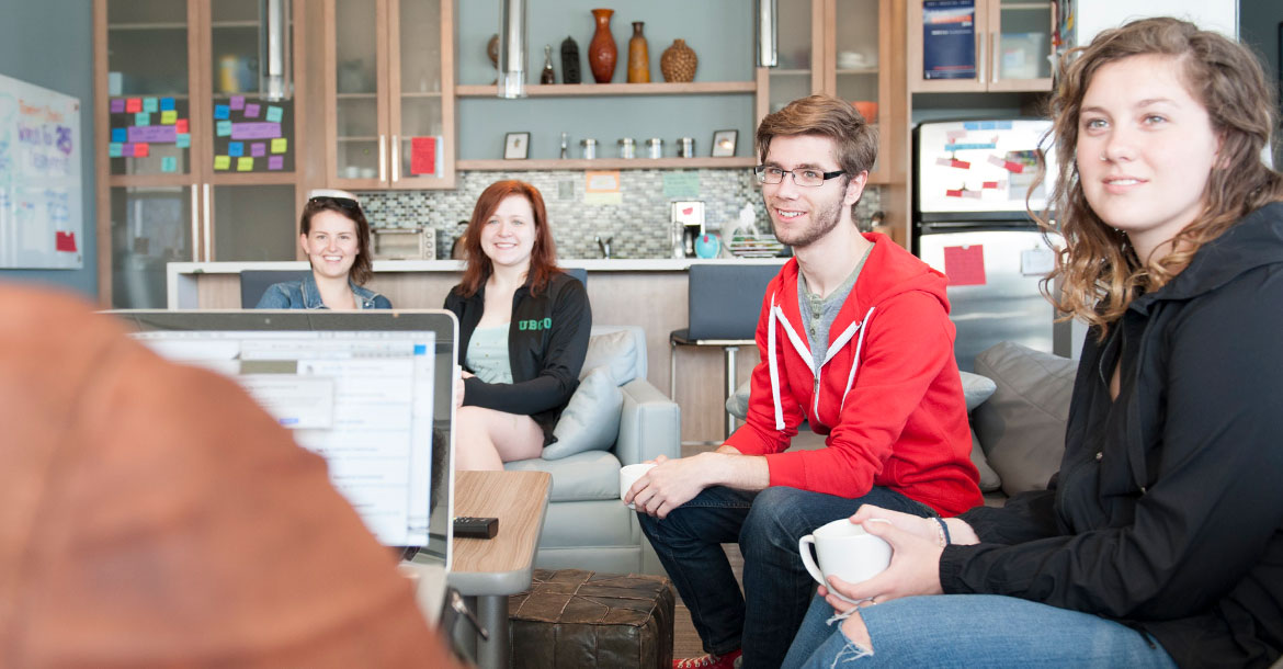 four students sitting on couches, enjoying the collegia space