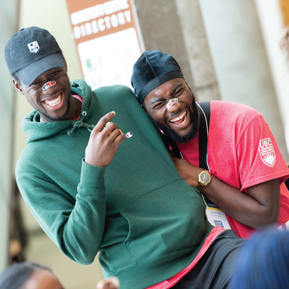 two students hugging and laughing with matching bandaids on their noses at Jump Start orientation week