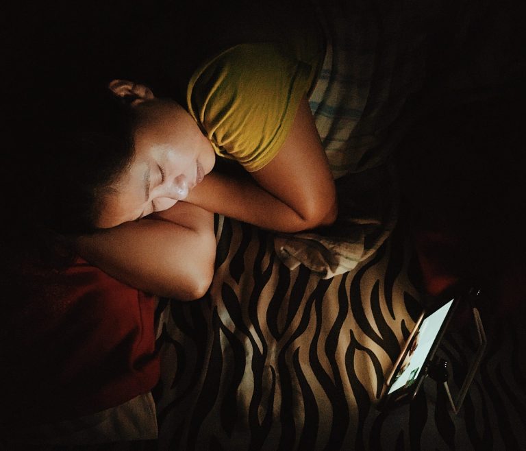 Girl in bed watching something on her device