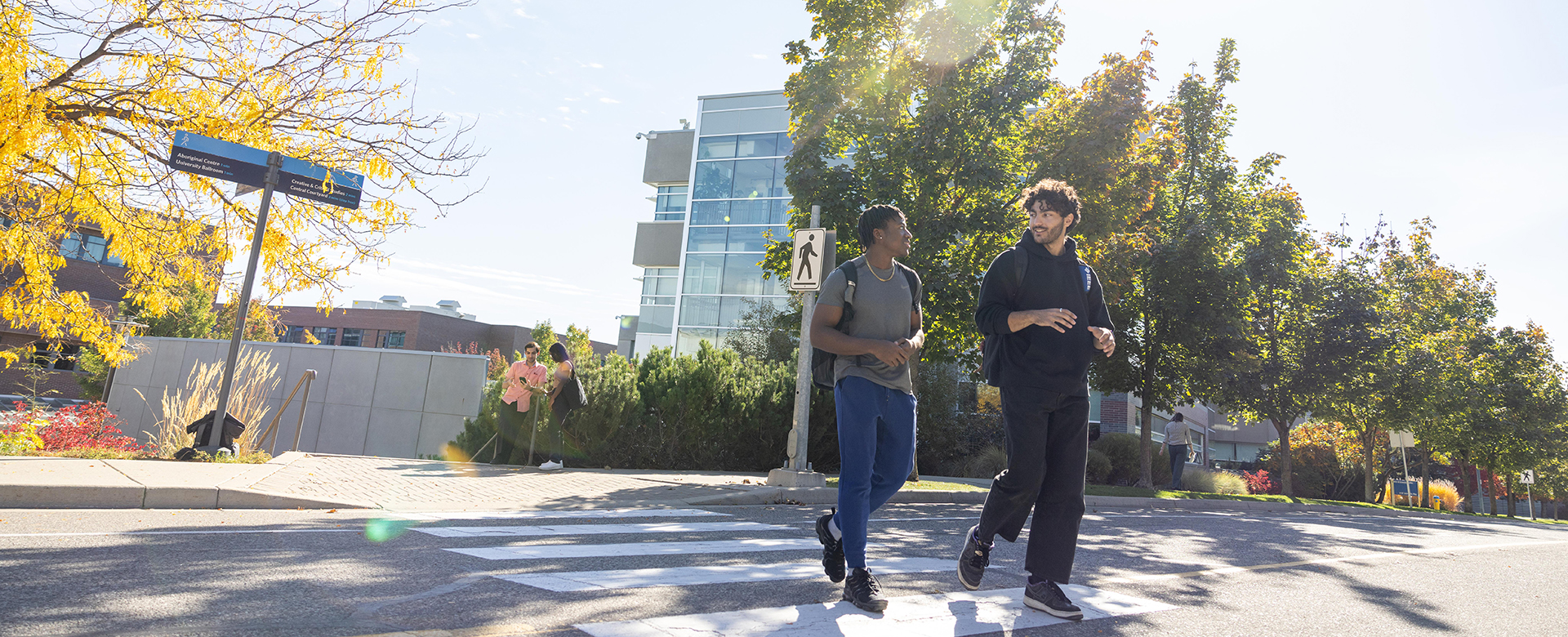 Two students walking on campus in autumn