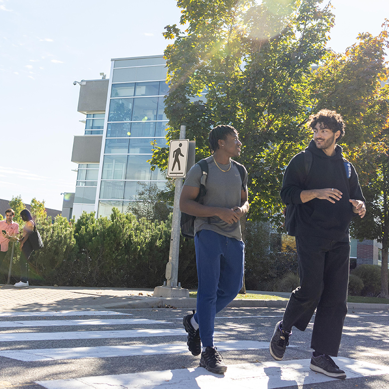 Two students walk on campus in autumn